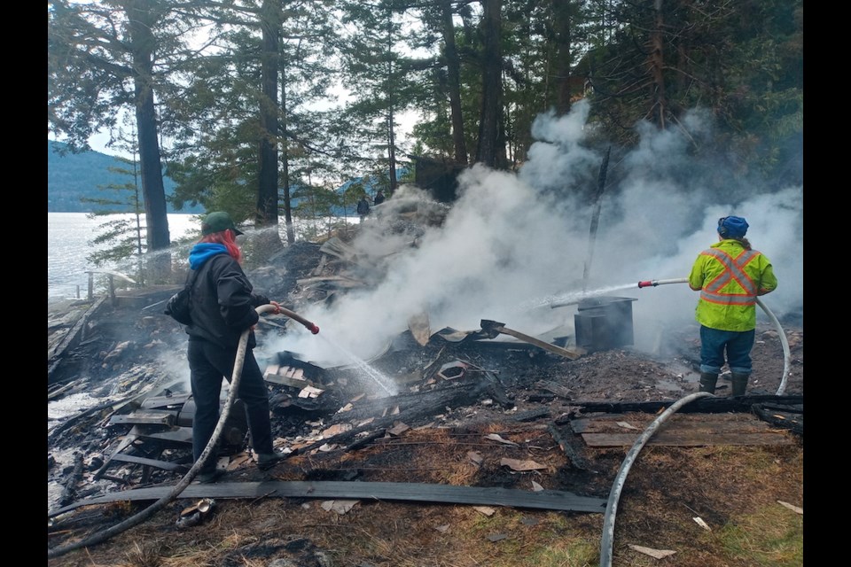 Gambier Island fire protection volunteers pumped sea water onto the burning cabin remains to prevent the fire's spread. 